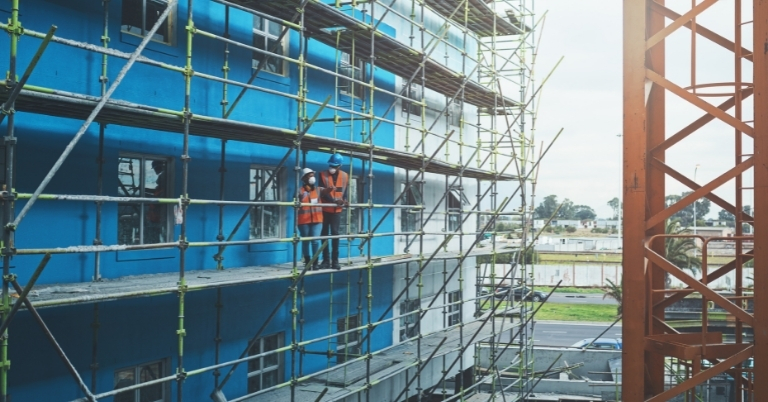 Construction workers standing on scaffolding