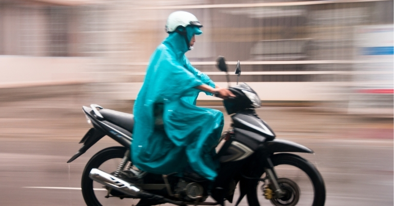 Image of someone riding a motorcycle in a rain ponchoo